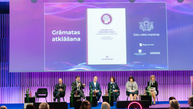 Grāmatas atklāšanas pasākums. Fonā redzams prezentācijas ekrāns ar grāmatas vāku un Datu valsts inspekcijas logo, priekšplānā - auditorija.